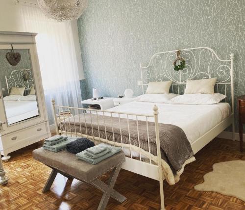 Schlafzimmer mit einem weißen Bett und einem Spiegel in der Unterkunft Cortile Gancia - Sweet House in Narzole