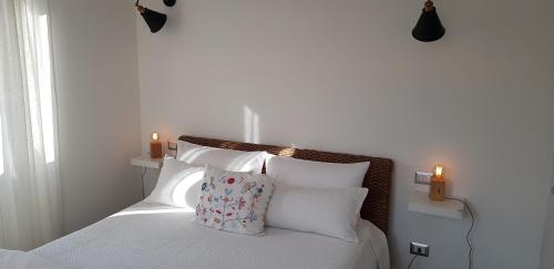 a bedroom with a bed with white sheets and two candles at Bellagio Holiday Home in Bellagio