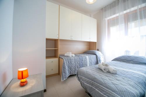 1 dormitorio con 2 camas y mesa con lámpara en Appartamento Marevivo en Francavilla al Mare