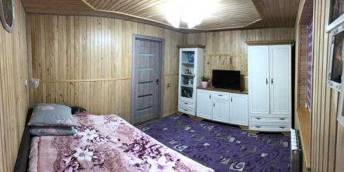 a bedroom with a bed and a tv in it at Карпатська ніч in Plav'ya