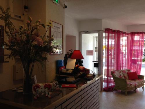 a living room with a table with a vase of flowers at Hôtel de La Poste in Douvaine