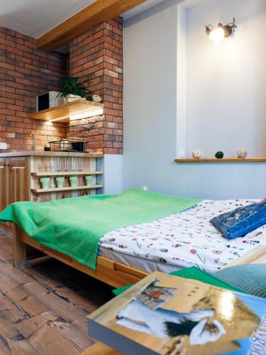 a room with a bed and a table and a kitchen at Pokoje u Karolinki in Zakopane