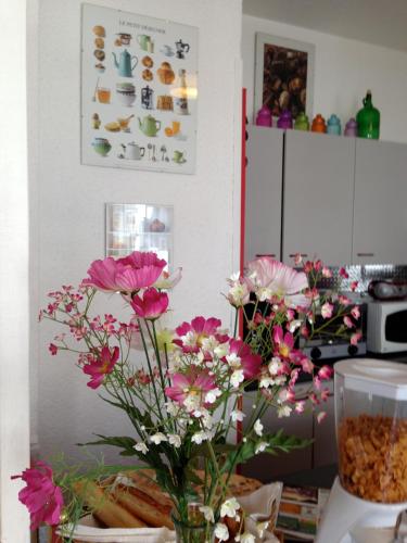 a kitchen with flowers in a vase on a table at Hôtel de La Poste in Douvaine