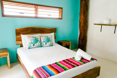 1 dormitorio con 1 cama en una habitación con paredes azules en PENINSULA STAYS 3BR House Tiburón Ballena BEST in HOLBOX en Holbox Island