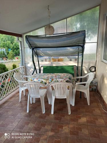 a porch with a table and chairs on a balcony at Karali Apartments in Lagadin