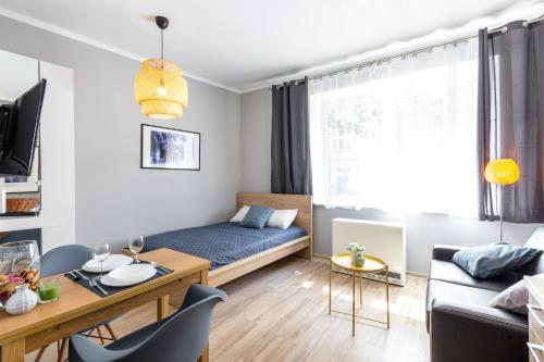 mały salon z łóżkiem i stołem w obiekcie FriendHouse Apartments w Krakowie