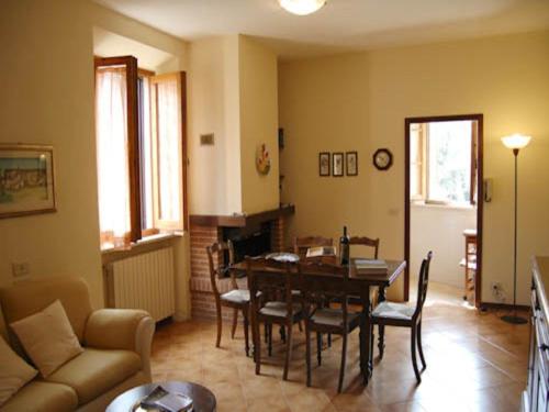 ein Wohnzimmer mit einem Tisch, Stühlen und einem Sofa in der Unterkunft La Casa di Lucia in Castelmuzio