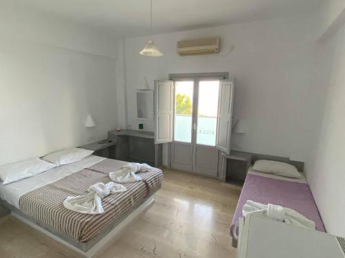 a bedroom with a large bed and a window at Hotel Hellas in Fira