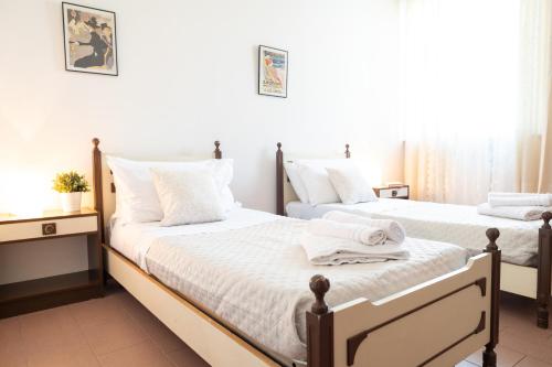 two beds in a bedroom with white sheets and towels at L'angolo di Gioia in Montecarlo