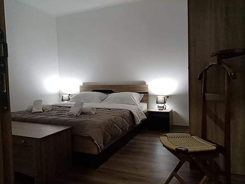 a bedroom with a large bed with two lights on it at Dany Apartments in Gevgelija