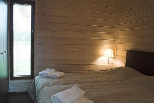 a bedroom with a bed in a wooden wall at Kiurunrinne Villas in Imatra