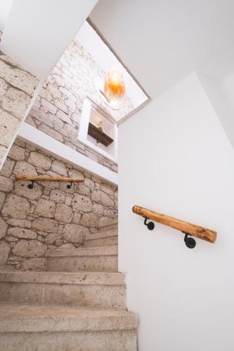 a staircase in a house with a stone wall at ZOE ALAÇATI in Alacati