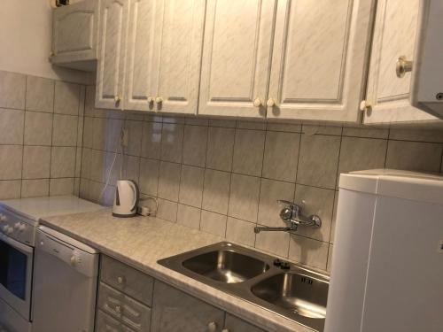 cocina con fregadero y armarios blancos en Apartman Štefanija, en Novi Vinodolski