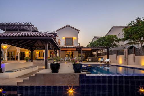 a villa with a swimming pool and a house at Frank Porter - The Villa, Ponderosa in Dubai