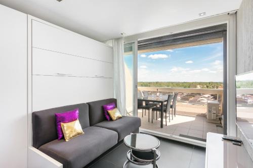 d'un salon avec un canapé et un balcon. dans l'établissement Village Naturiste R4N - Le Blue Light Heliopolis Sea View Luxe, au Cap d'Agde