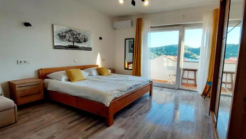 een slaapkamer met een bed en een groot raam bij Guest House Galeb in Supetarska Draga