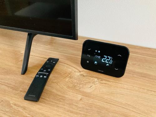 a tv and a remote control sitting on a table at Residence Kotel in Rokytnice nad Jizerou