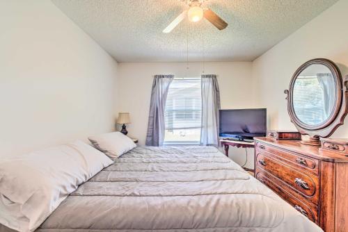 a bedroom with a bed and a mirror and a dresser at Sunny Home in The Villages with Lanai and Pool Access! in The Villages