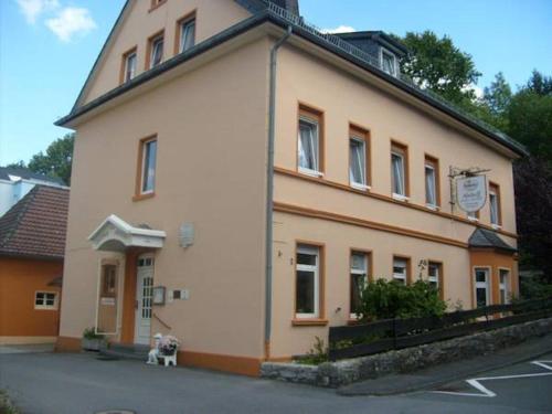 a building with a dog sitting in front of it at Pension Abshoff in Meschede