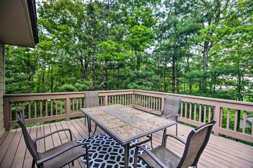 a patio table and chairs on a deck with trees at Cozy Wintergreen Resort Condo Walk to Ski Lifts! in Lyndhurst