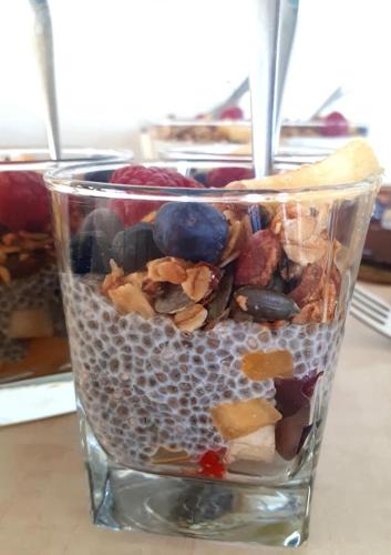 a glass cup filled with different types of food at Yehelim Boutique Hotel in Arad