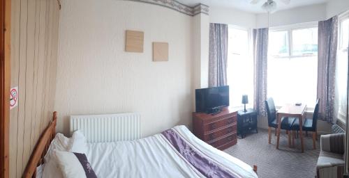 a bedroom with a bed and a tv in it at 2 berth ground floor flat Apsley 2 in Great Yarmouth