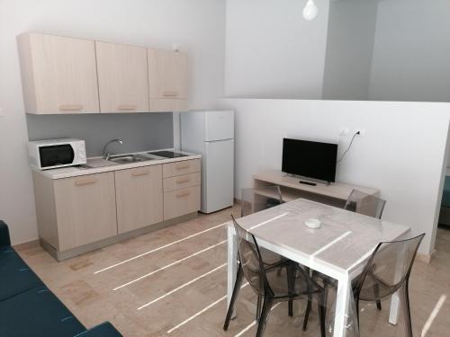 a kitchen with a table and a kitchen with a microwave at Zibibbo Beach Apartments - Trapani in Trapani