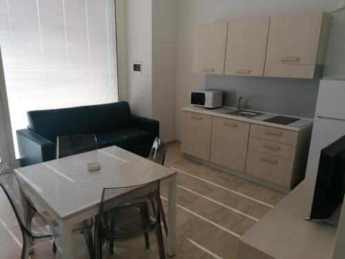 a living room with a couch and a table and a kitchen at Zibibbo Beach Apartments - Trapani in Trapani