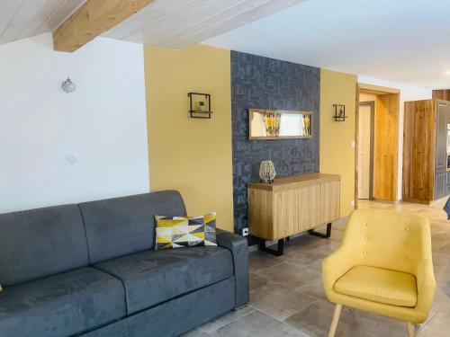 sala de estar con sofá azul y silla amarilla en Le Gîte de mon grand père, en La Bresse