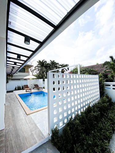 a patio with a white fence and a swimming pool at Ban Rub Lom Pool Villa 3 difference villas in Rayong