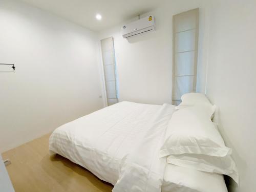 a white bedroom with a bed with white sheets at Ban Rub Lom Pool Villa 3 difference villas in Rayong