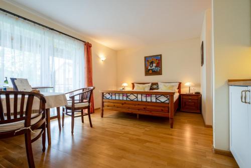 a living room with a dining room table and a bedroom at Gästehaus Casa Cristina in Bad Krozingen