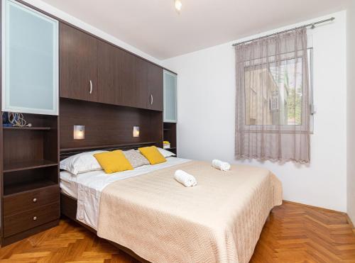 1 Schlafzimmer mit 2 Betten und gelben Kissen in der Unterkunft Apartment Edita in Omiš