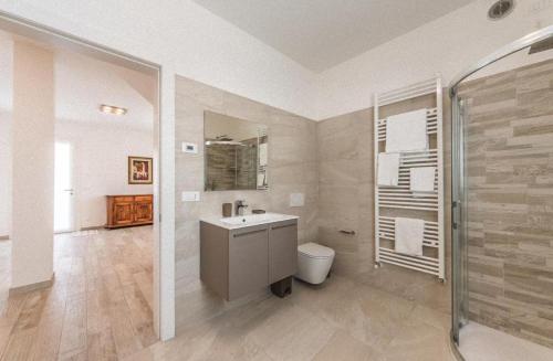 een grote badkamer met een wastafel en een douche bij Home situated not far beach in Torre di Fine