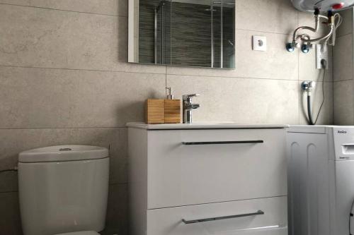 La salle de bains est pourvue de toilettes blanches et d'un lavabo. dans l'établissement M3 Terrace. Cool apartment 15 min center by metro, à Esplugues de Llobregat