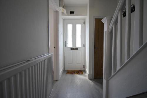 a hallway with a white door with a window at Risca Retreat in Risca