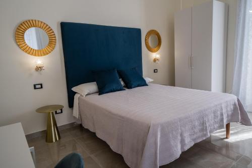 a bedroom with a large bed with a blue headboard at Amaris in Palermo