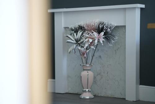 a vase with flowers in it in a room at Risca Retreat in Risca