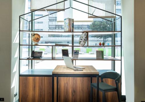 an office with a desk with a laptop and a window at ibis Styles Paris Meteor Avenue d'Italie in Paris