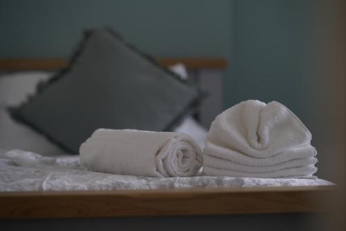 a pile of towels sitting on top of a bed at Risca Retreat in Risca