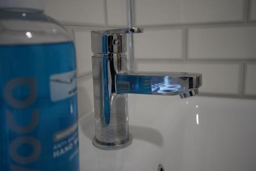 a water faucet next to a can on a counter at Risca Retreat in Risca