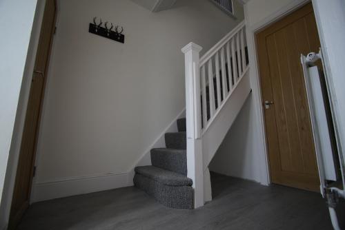 a hallway with a staircase and a wooden door at Risca Retreat in Risca