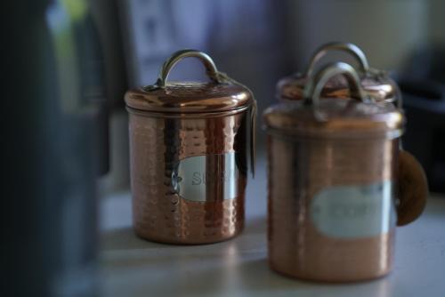 two copper containers sitting on top of a counter at Risca Retreat in Risca