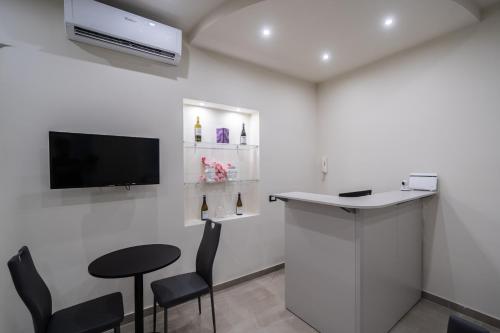 a bar in a room with a tv and chairs at Amaris in Palermo