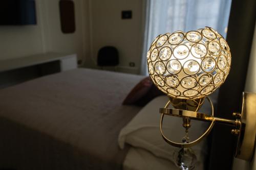a lamp in a room with a bed at Amaris in Palermo