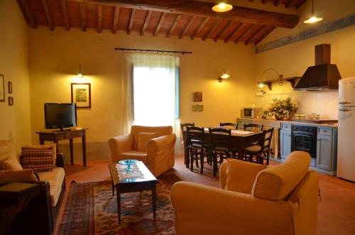 a living room with couches and a table and a kitchen at Cortona Resort-Le Terre Dei Cavalieri in Cortona