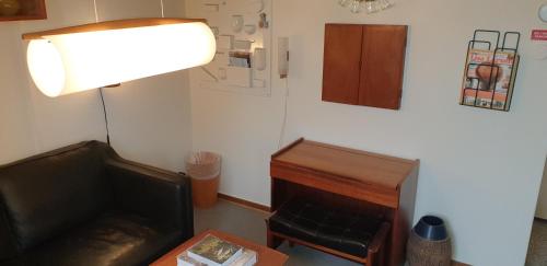 a room with a couch and a desk and a lamp at Hotell Hanöbris på Kivik in Kivik