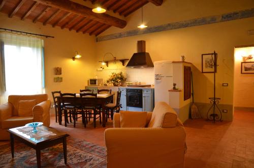 a kitchen and living room with a table and a refrigerator at Cortona Resort-Le Terre Dei Cavalieri in Cortona