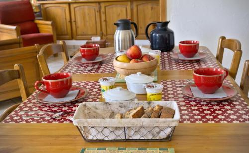 een tafel met eten en bekers en een fruitschaal bij Au Diapason Chambres d'hôtes montagne in Auzet