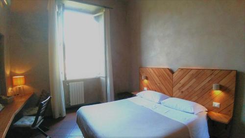 a bedroom with a large white bed and a window at Folia in Rome